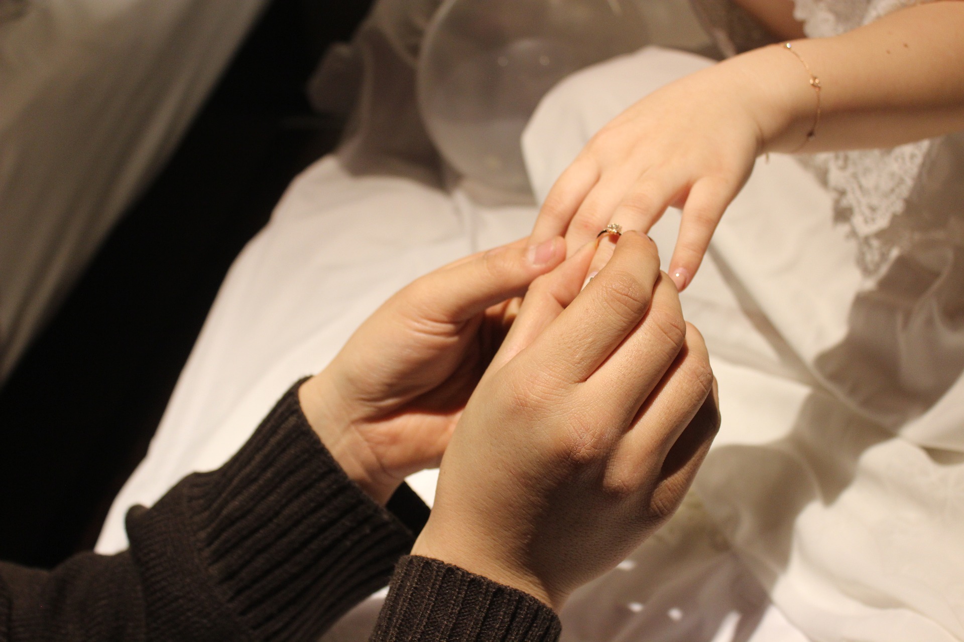 Groom wearing their wedding ring to her bride
