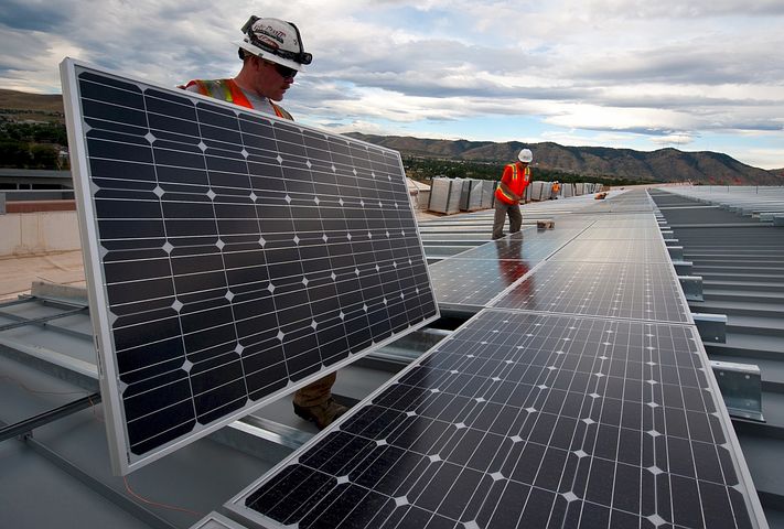 Two workers offering solar panel financing options
