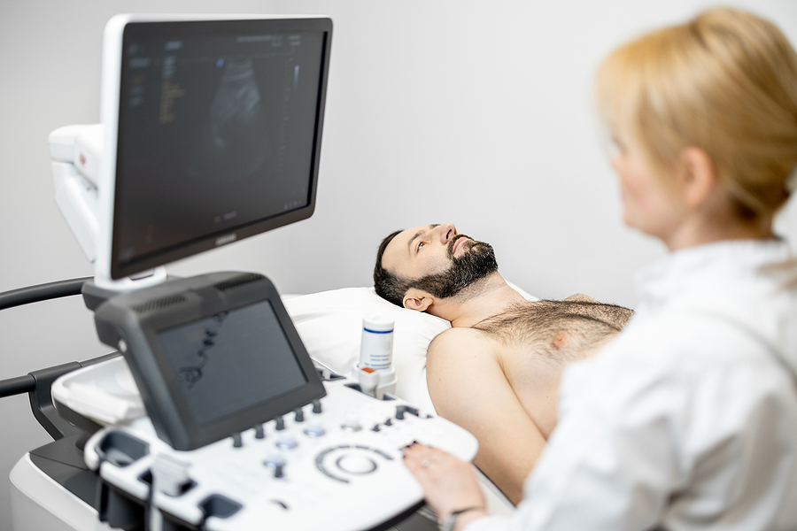 Doctor doing a liver scan to a male patient